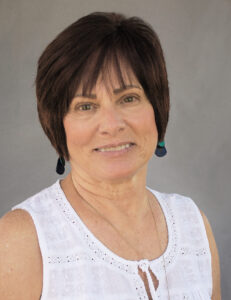 Portrait of a smiling mature woman with short dark hair.
