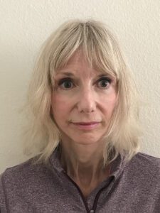 Portrait of a woman with blonde hair and a neutral expression.