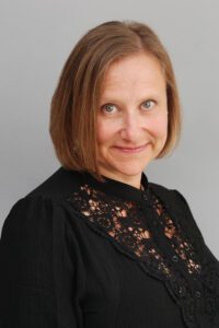 Professional woman with a friendly smile and short brown hair.