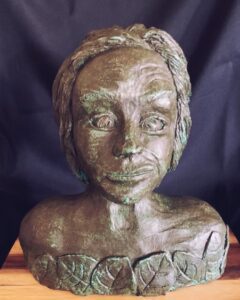 A bronze bust sculpture of a person with a serene expression.