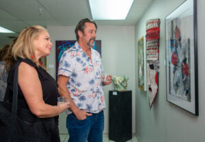 Two people admire artwork in a gallery setting.