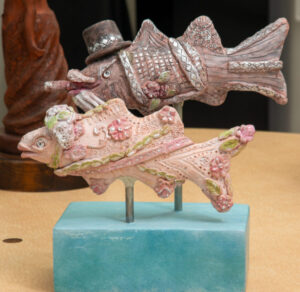 Two ornate conch shells mounted on a blue base.