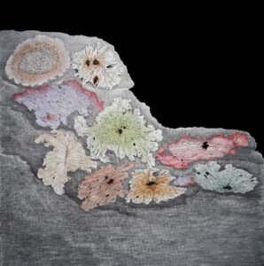 Colorful crocheted flowers arranged on a gray background.