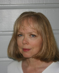 Portrait of a middle-aged woman with blonde hair and blue eyes.