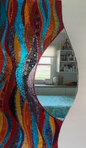 Colorful wavy mirror reflecting a cozy bedroom with a window and shelves.