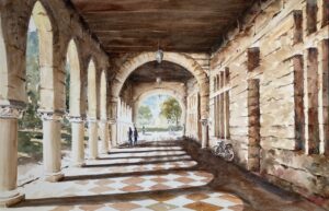 Sunlit stone corridor with arches and a checkered floor.