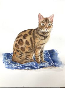 Watercolor painting of a spotted cat sitting on a blue patterned cloth.