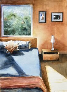 Cozy bedroom with warm walls, sunlight, and decorative pillows.