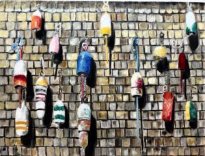 Colorful fishing buoys hanging on a wooden shingled wall.