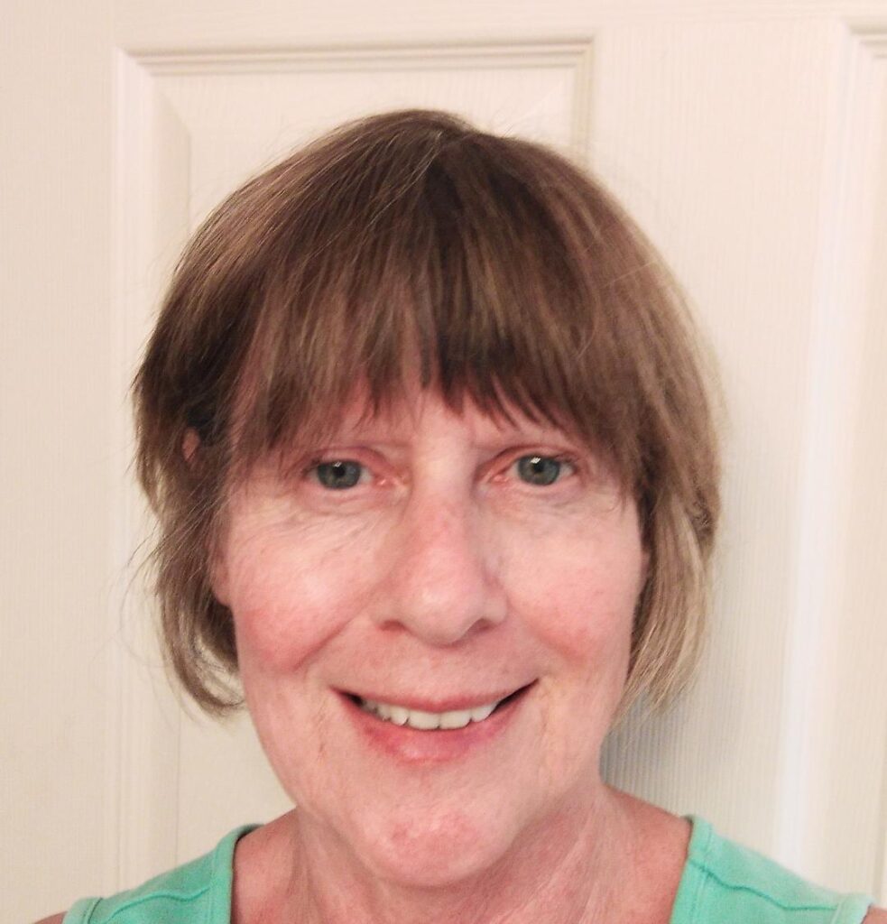 Smiling elderly woman with light brown hair and bangs.