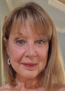 Close-up portrait of a woman with blonde hair and earrings.