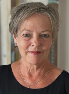 Portrait of a confident older woman with short gray hair and a subtle smile.