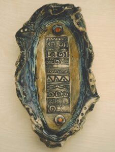 Intricately carved wooden artifact with tribal patterns and symbols.