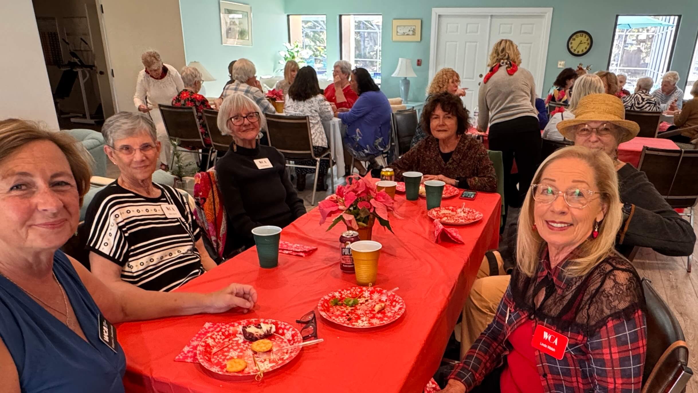 Elderly friends enjoying a festive lunch together at a decorated table.