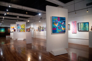 Art gallery interior showcasing colorful paintings on white walls.