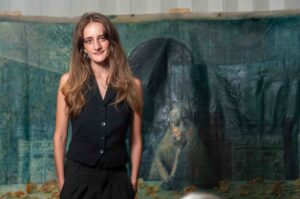 Woman posing in front of a large, abstract painting.