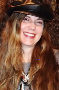 Smiling woman with long hair and a hat.
