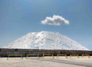 Covered mound with cloud in blue sky.