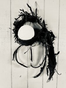 Abstract artwork with black wreath and circle.