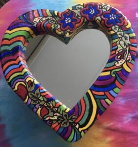 Colorful heart-shaped mirror with floral patterns.